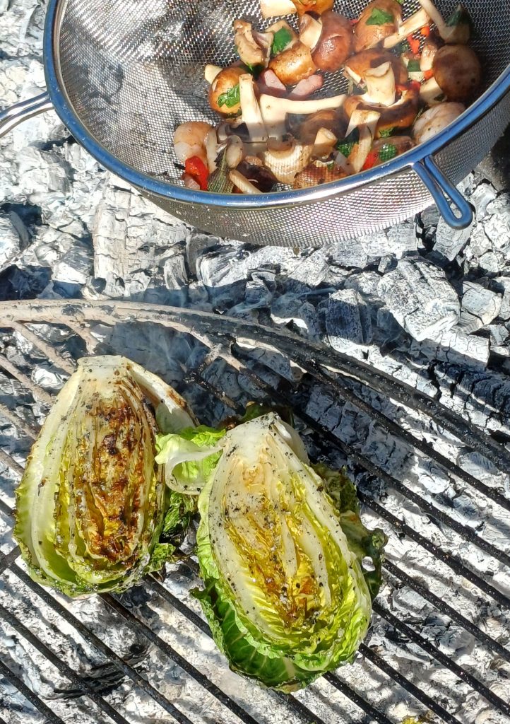 Salat wird gegrillt, Pilze garen im Sieb direkt in der Glut